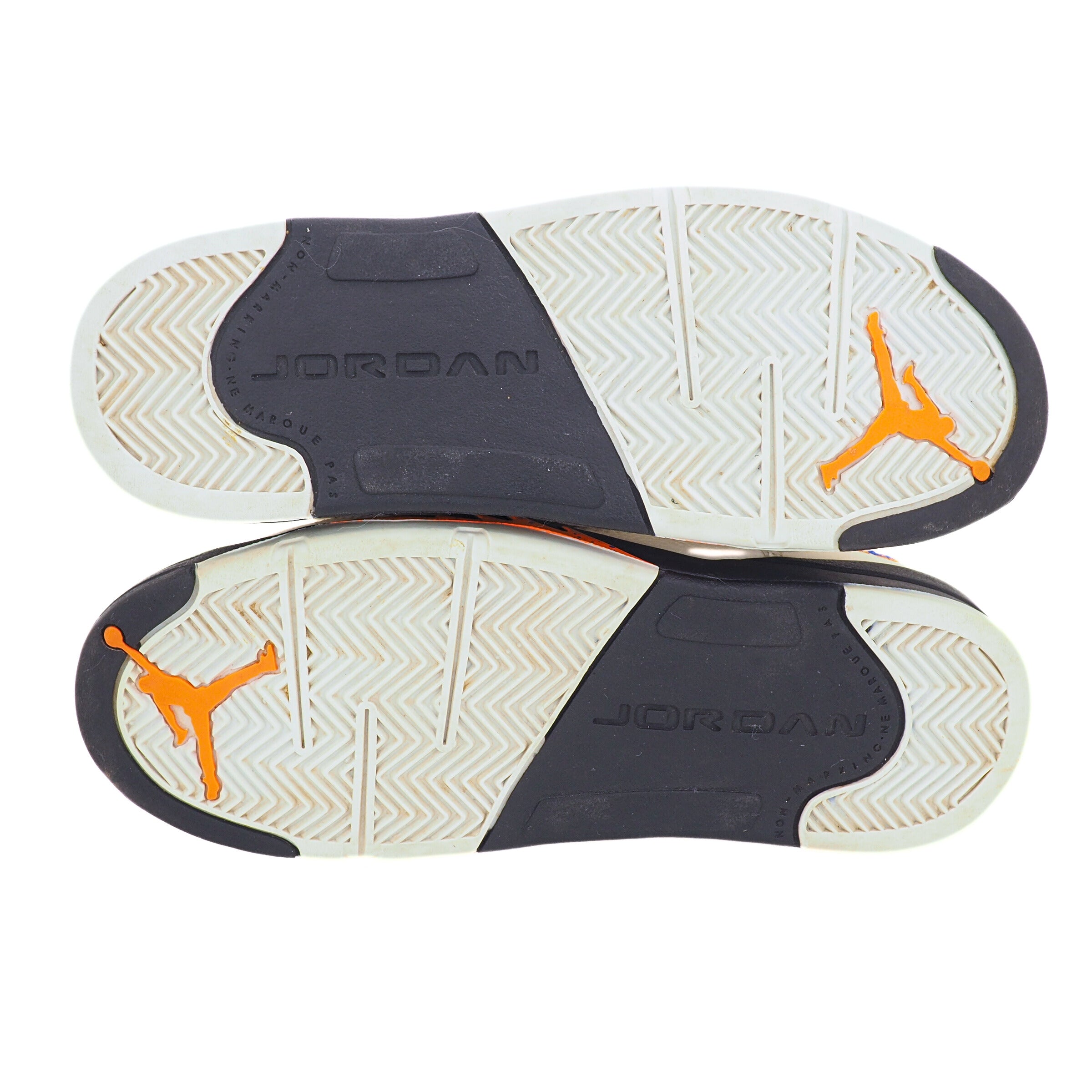 Close-up of Jordan brand shoe soles with orange logo on a white background