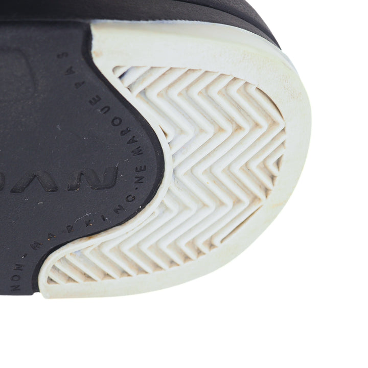Close-up of a shoe sole with a zigzag pattern and brand logo on a white background