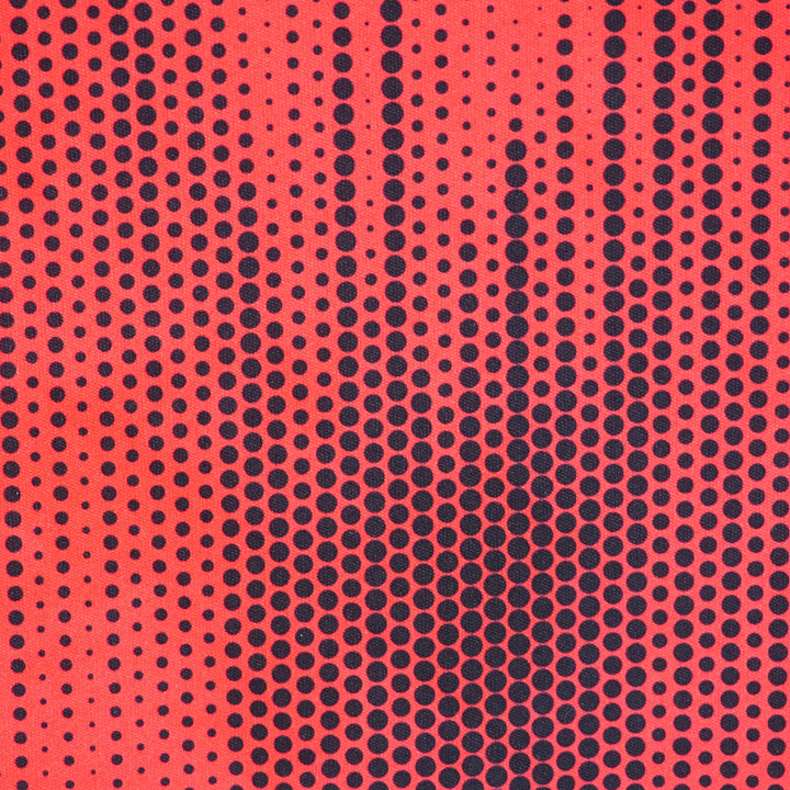 Close up of a red soccer jersey with a black polkadot pattern