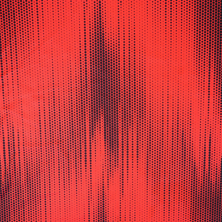 Close up of a red soccer jersey with a black polkadot pattern