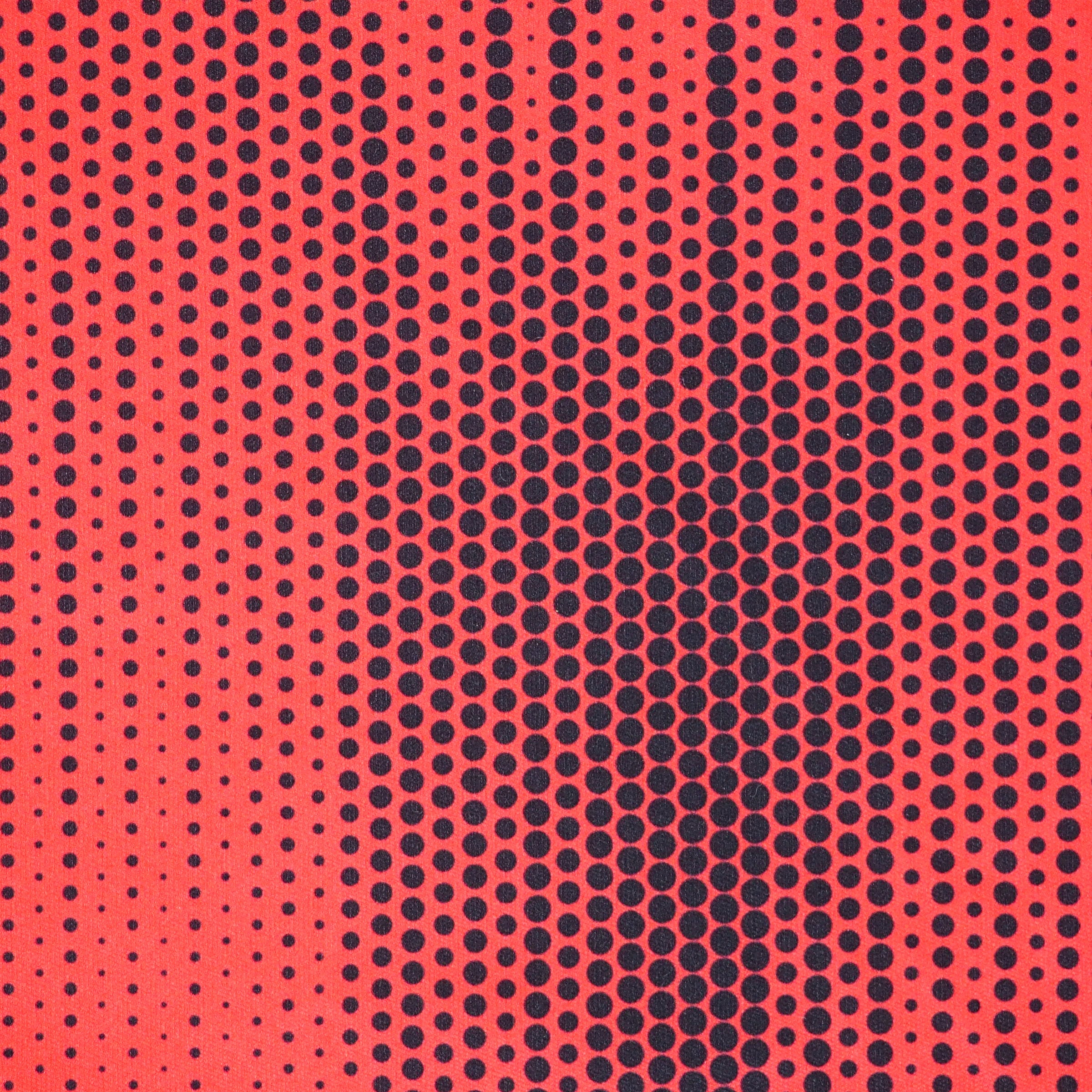 Close up of a red soccer jersey with a black polkadot pattern