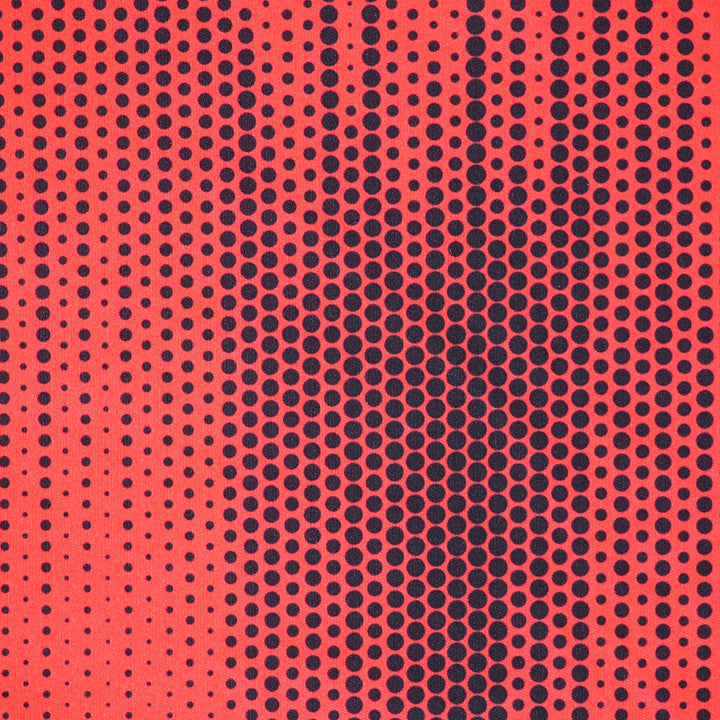 Close up of a red soccer jersey with a black polkadot pattern