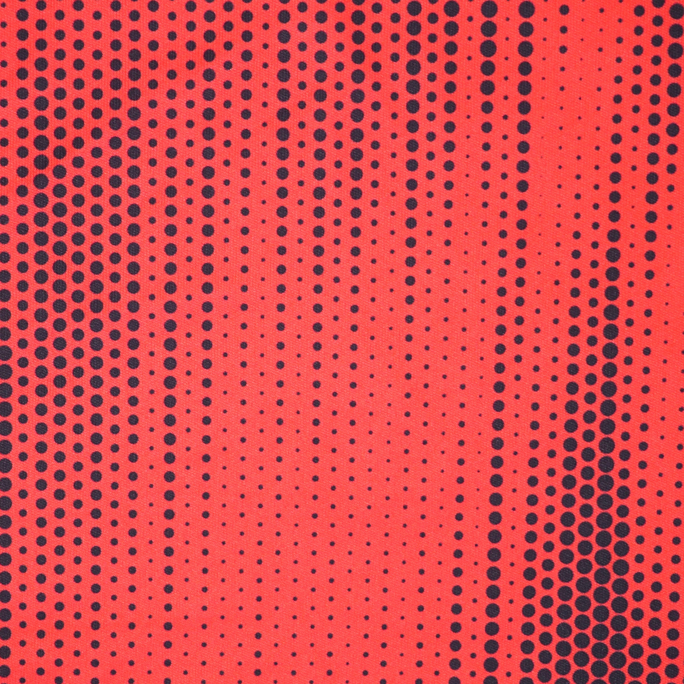 Close up of a red soccer jersey with a black polkadot pattern