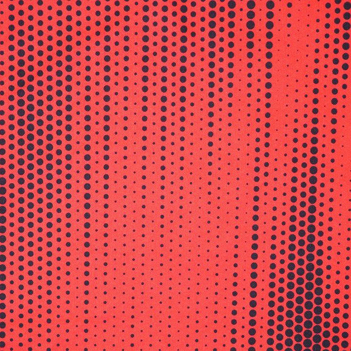 Close up of a red soccer jersey with a black polkadot pattern