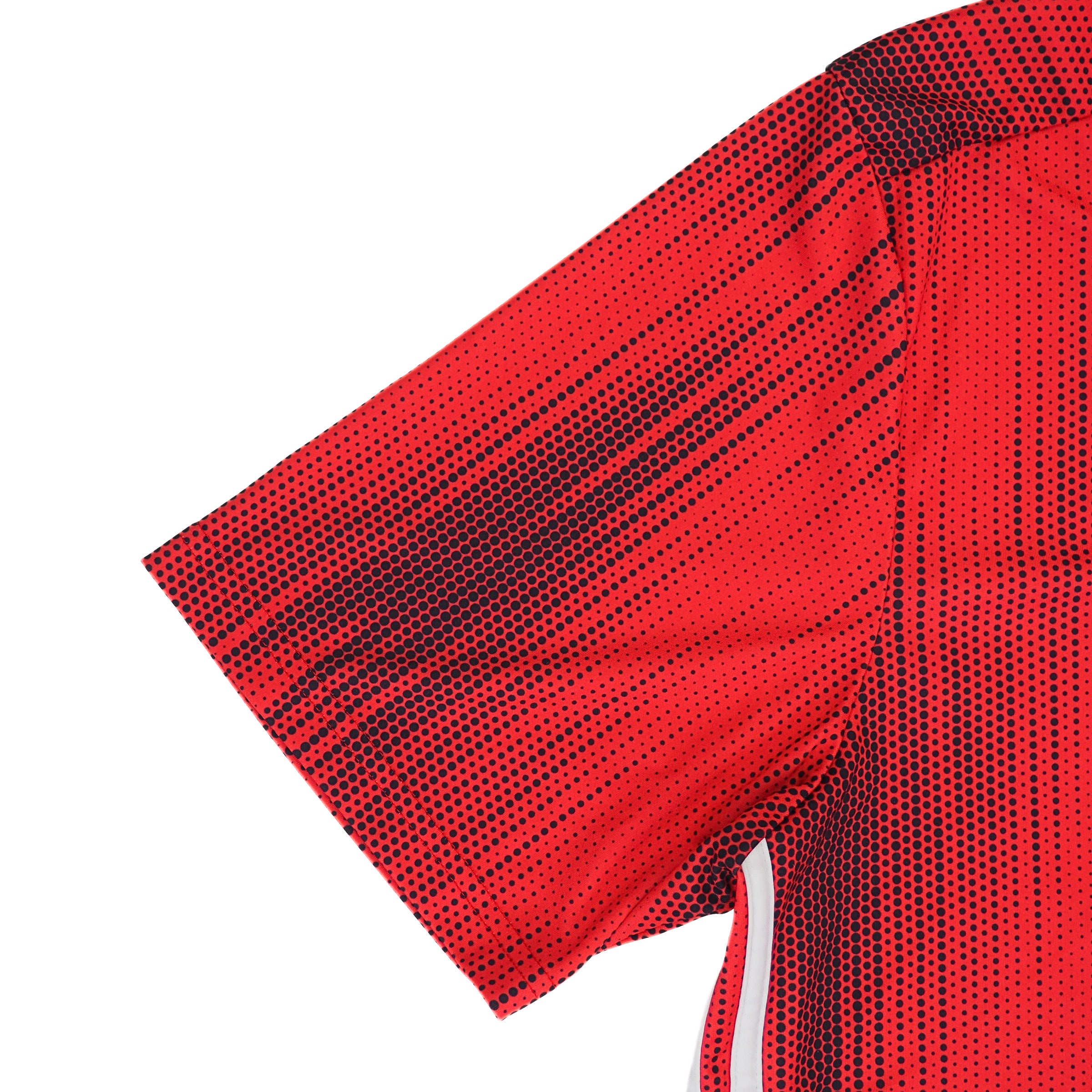 Sleeve detail of a red soccer jersey with black polkadots