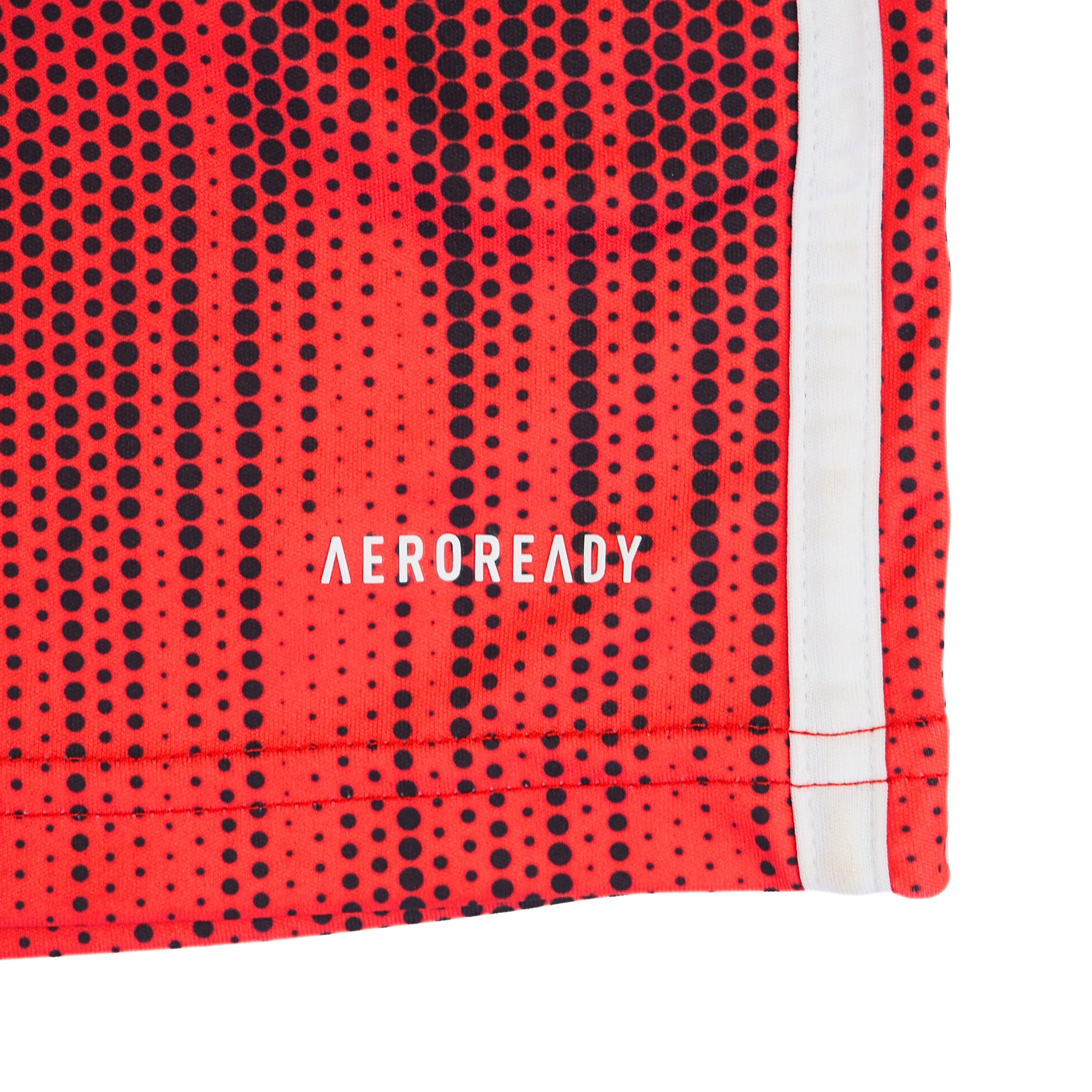 Close up of the hem of a red and black soccer jersey with the branding 'Aeroready'