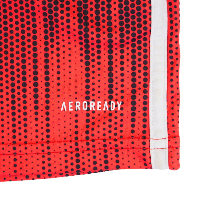 Close up of the hem of a red and black soccer jersey with the branding 'Aeroready'