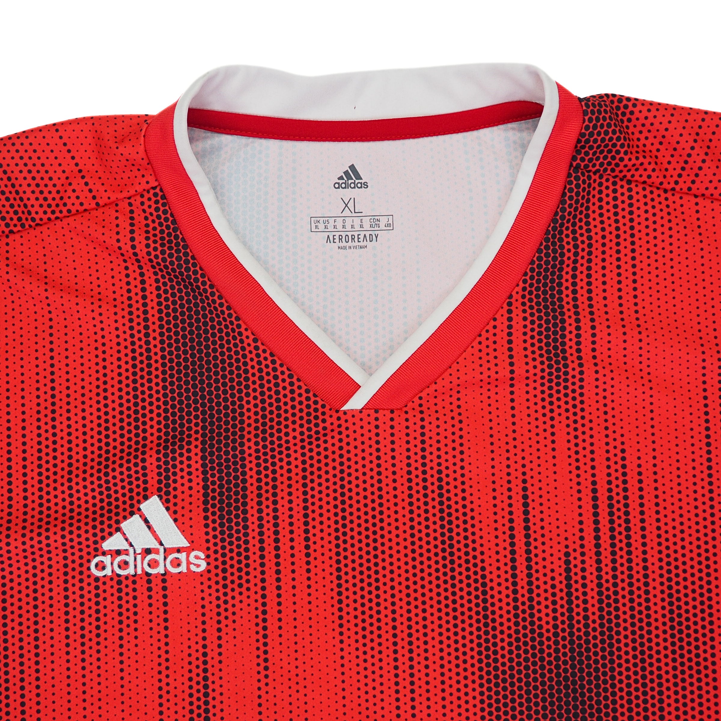Close up of the chest and collar of a red and black adidas soccer jersey on a white background