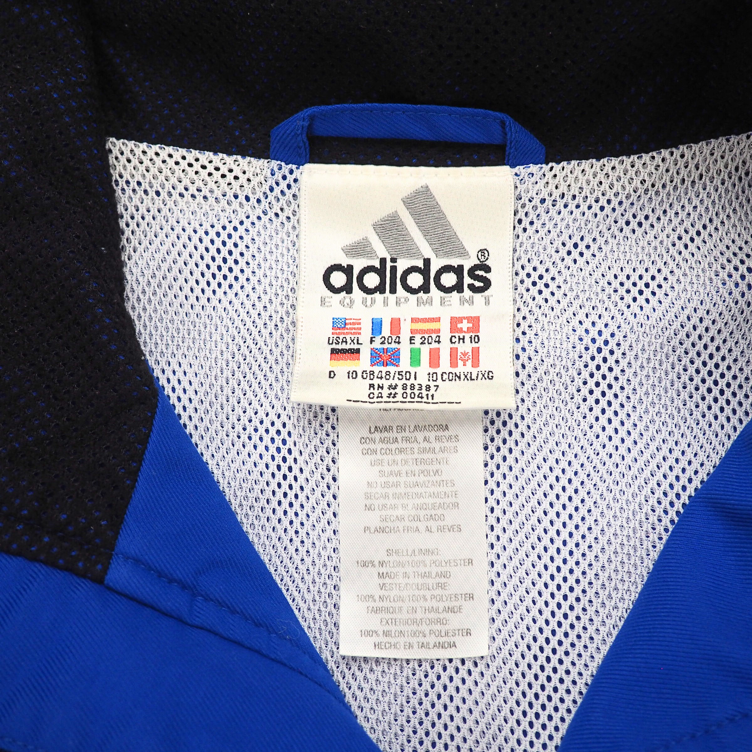 Close up of an adidas equipment flag tag on the inside collar of a blue jacket with mesh lining
