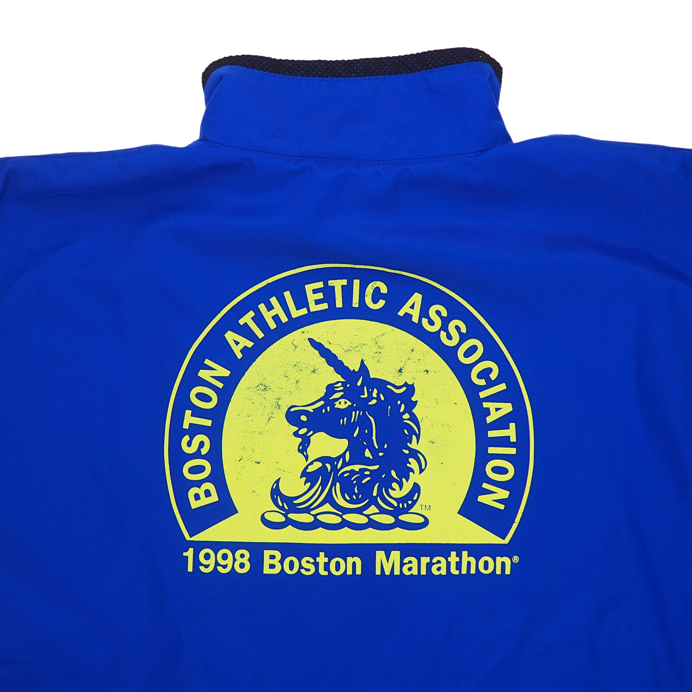 Detail of a logo on the back of a blue jacket that reads 'Boston Athletic Association 1998 Boston Marathon'