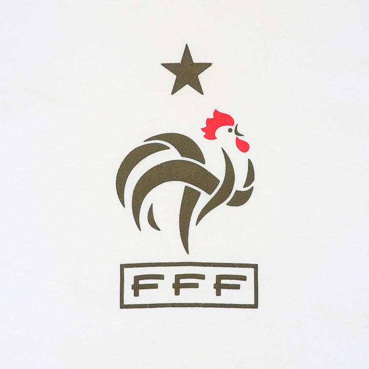 Close up detail of a white t-shirt with a graphic of a star, a cockerel and letters FFF