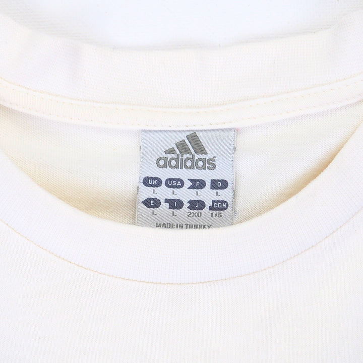 Close up of the collar of a white t-shirt with and adidas brand size tag