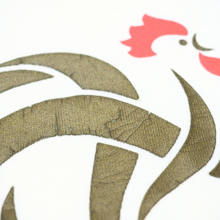 Close up of a vintage t-shirt graphic of a cockerel in gold and red 