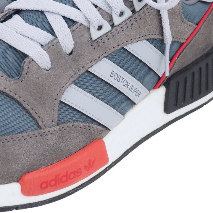 Close-up of an Adidas Boston Super sneaker with gray, red, and white design.