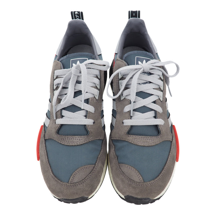 Pair of gray and blue adidas sneakers with light gray laces on a white background