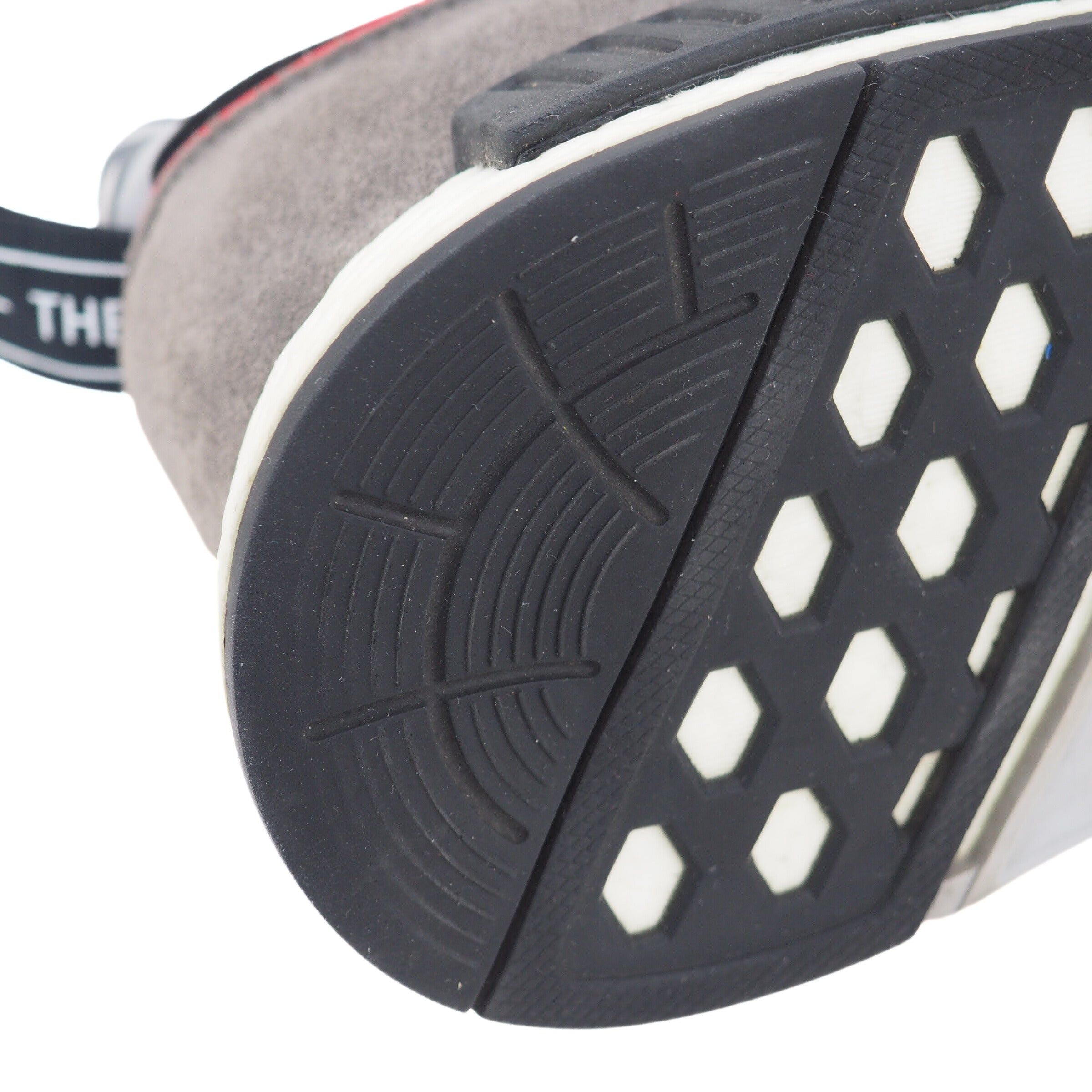 Close-up of a shoe sole heel with a textured pattern on a white background