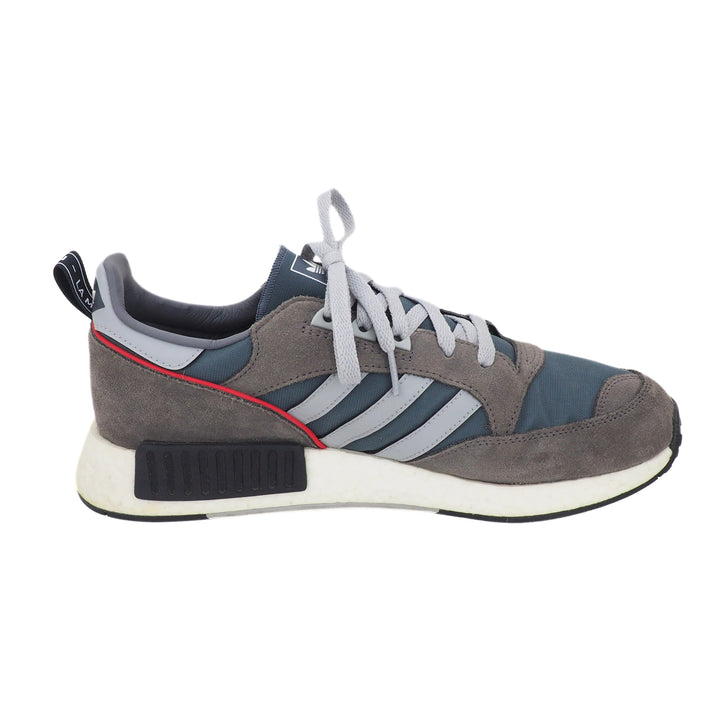 Gray and blue Adidas sneaker with grey stripes and red accents on a white background