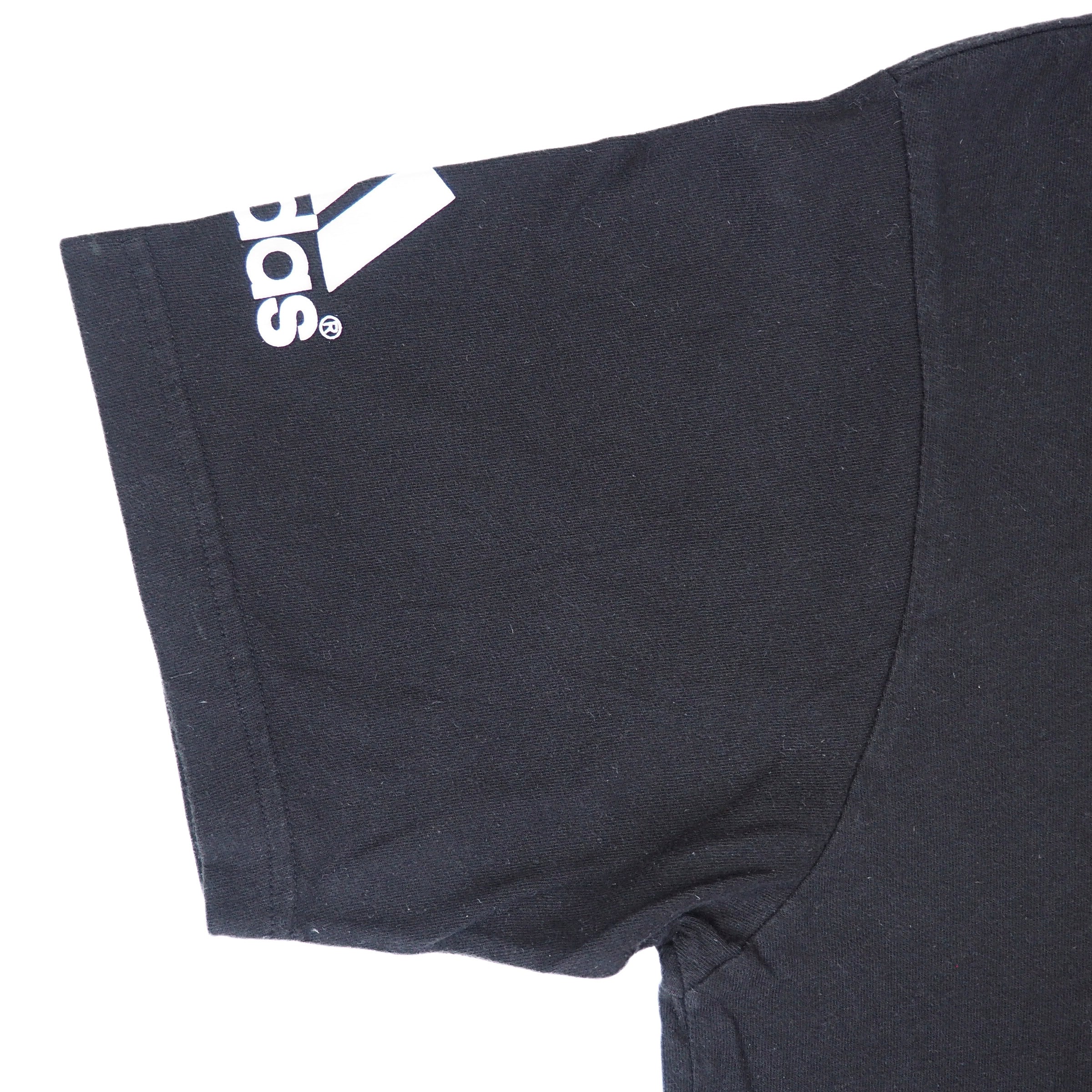 Detail of the sleeve of a black adidas t-shirt on a white background