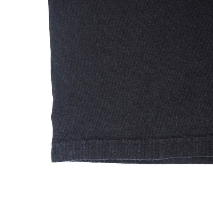 Close up of the hem and stitching of a black t-shirt on a white background