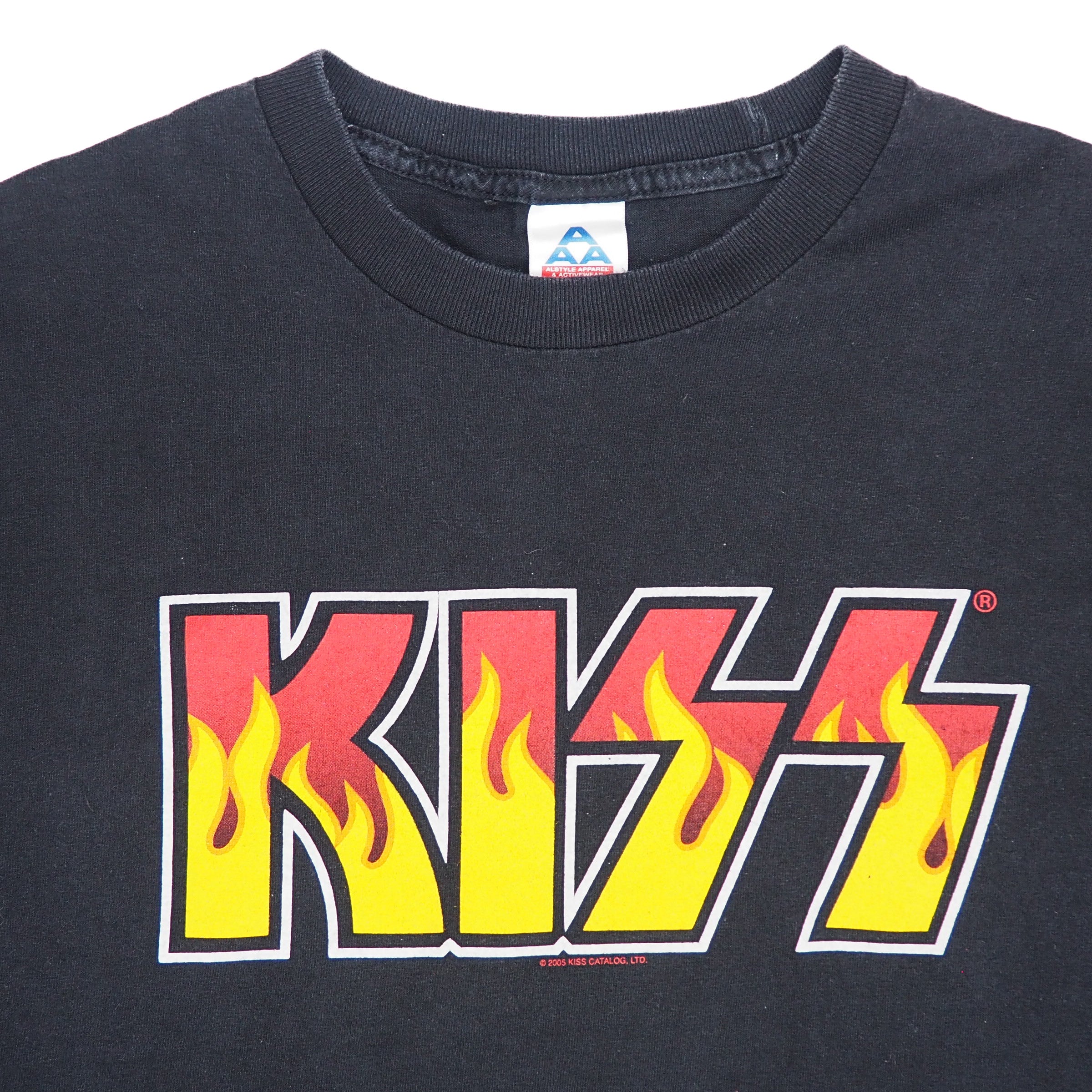 A black short-sleeve crewneck t-shirt featuring the KISS band logo printed across the chest in a red, yellow, and white flame design.