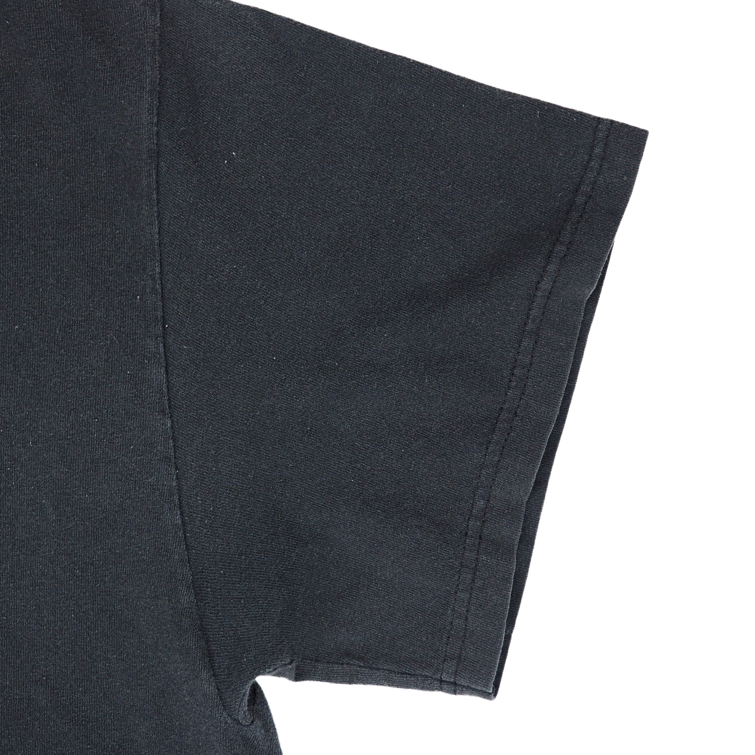 Close up of the sleeve of a black t-shirt on a white background
