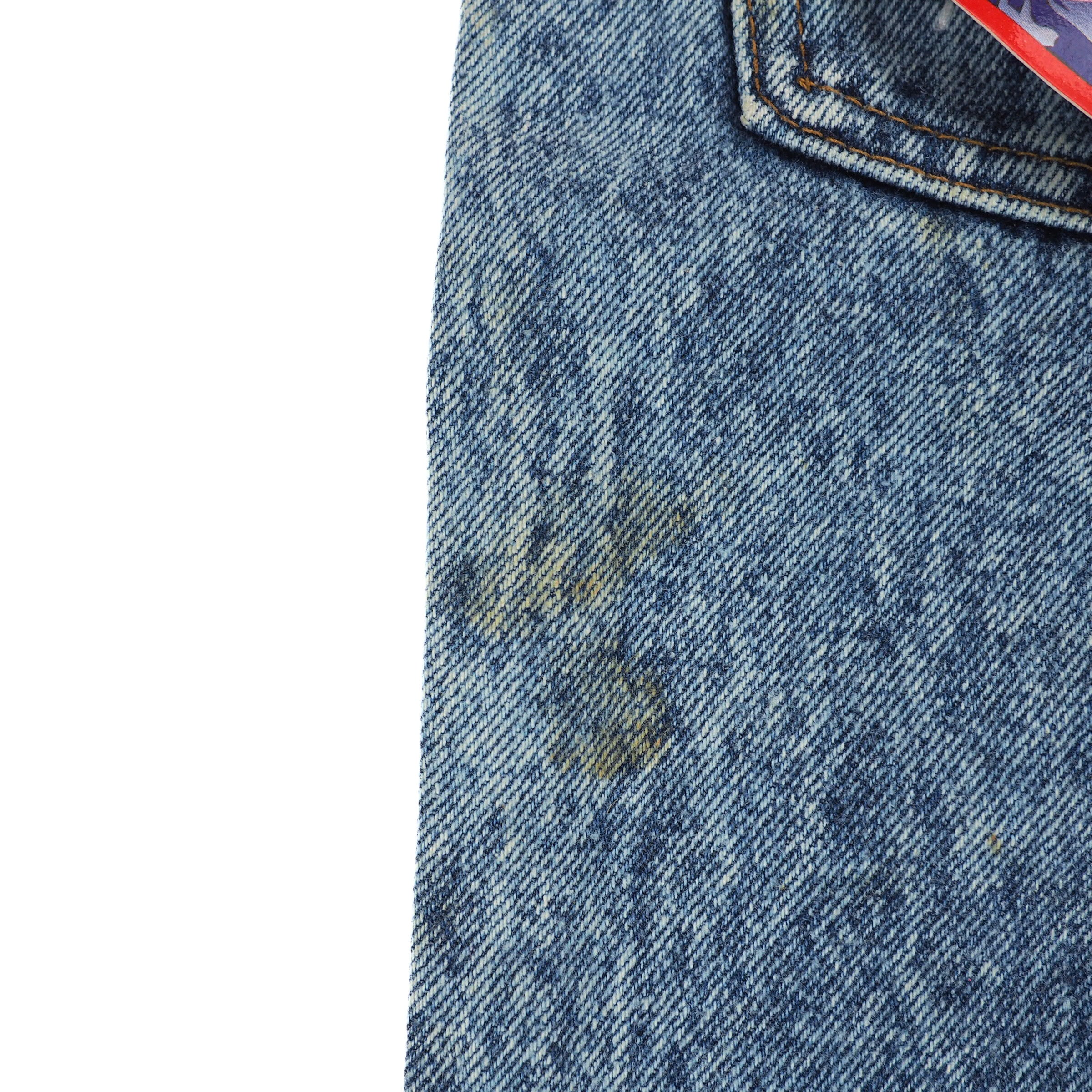 Close-up of a blue denim fabric with a stain on a white background