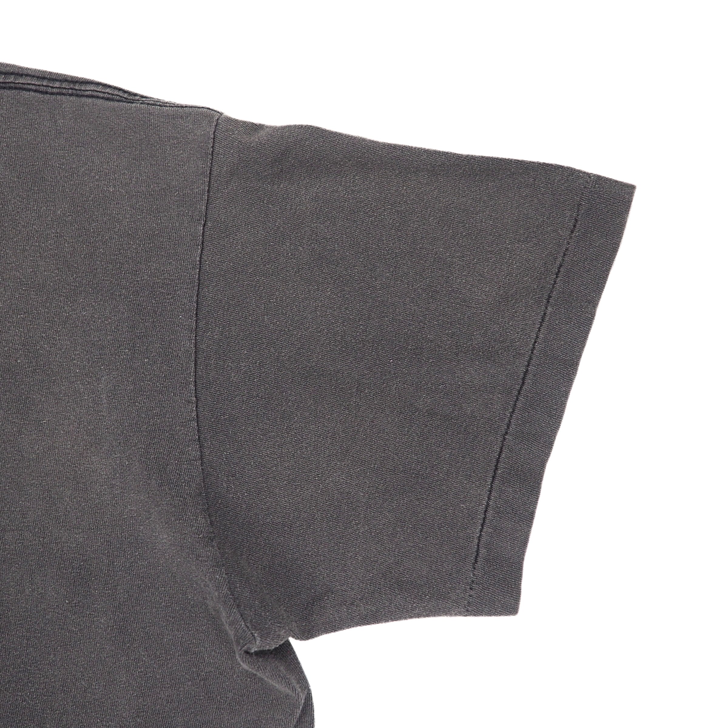 Close-up detail of a dark gray short-sleeve t-shirt sleeve with a clean hem and shoulder seam, set against a plain white background.