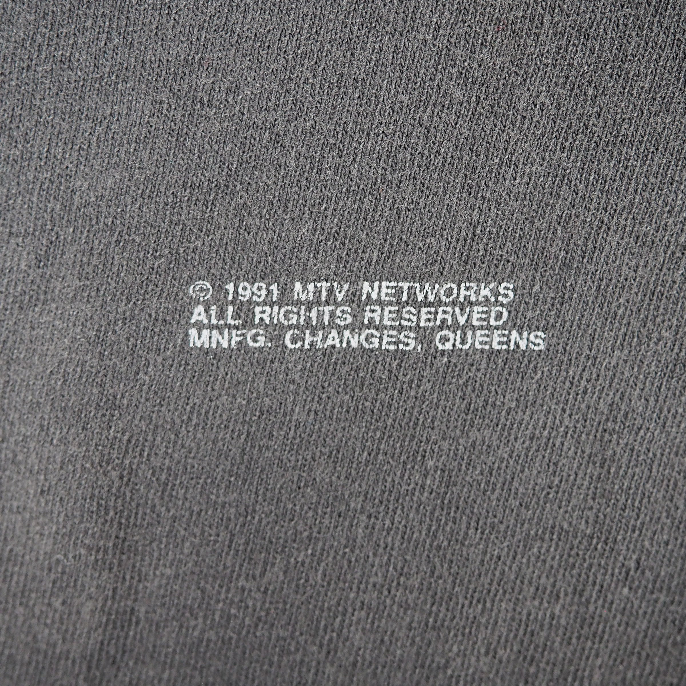 Close up of text printed on a cotton t-shirt that reads '1991 MTV Networks All Rights Reserved MNFG Changes Queens'