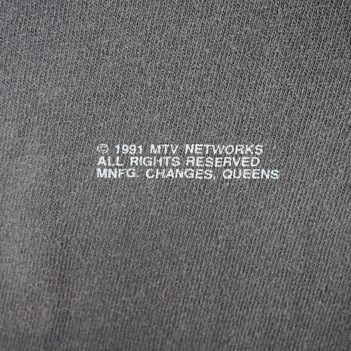 Close up of text printed on a cotton t-shirt that reads '1991 MTV Networks All Rights Reserved MNFG Changes Queens'