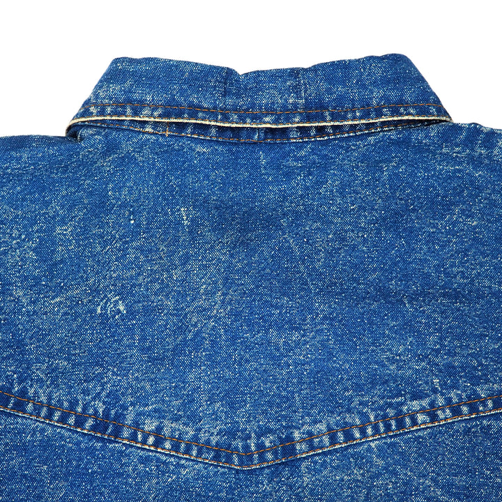 Close-up of blue denim shirt collar with stitching details on a white background