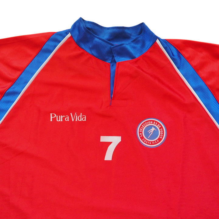 Red Costa Rica soccer jersey with blue accents, 'Pura Vida' text, and number 7 on a white background