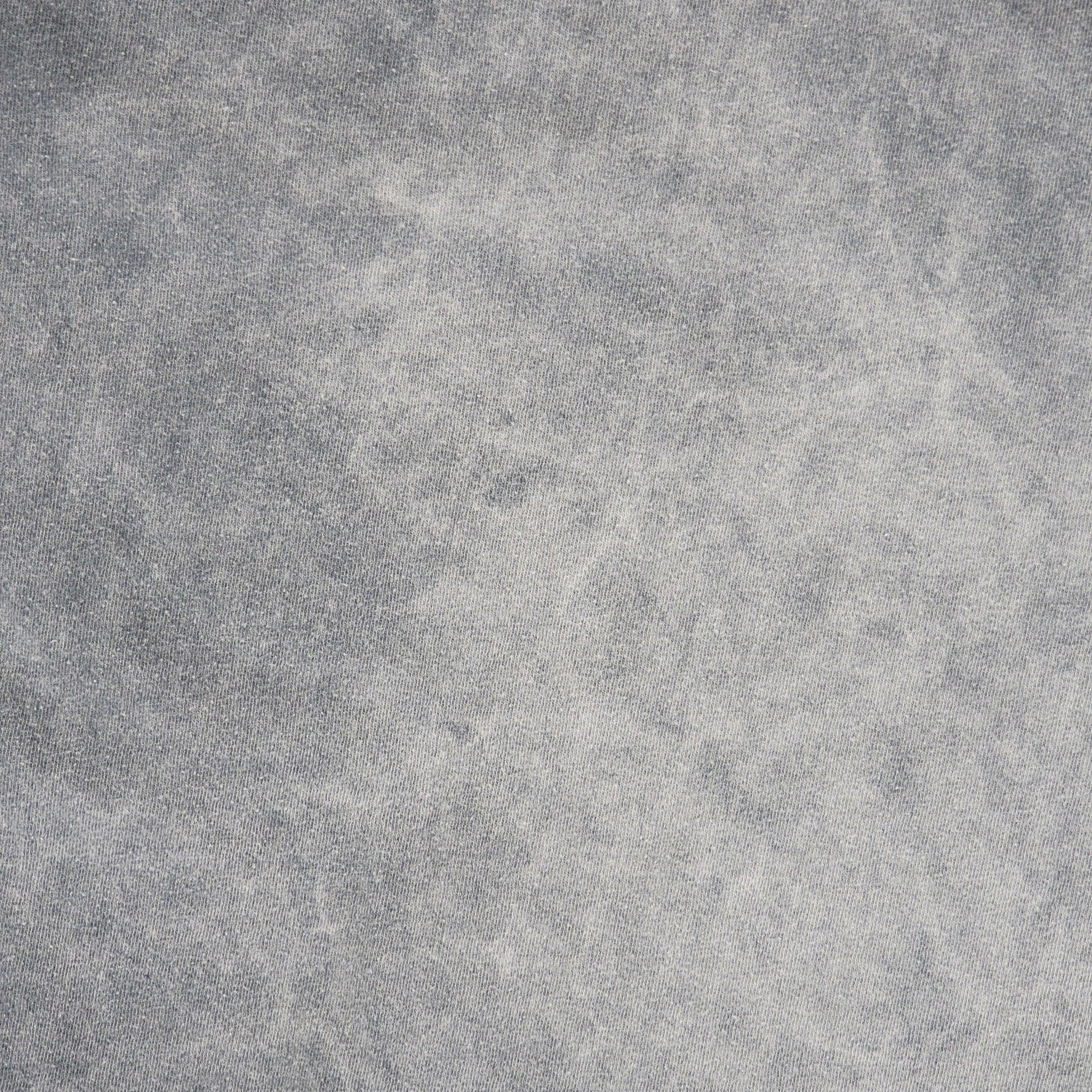 A close-up of a textured gray fabric with a mottled, stone-like or concrete-like finish.