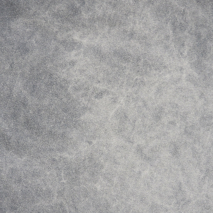 A close-up of a textured gray fabric with a mottled, stone-like or concrete-like finish.