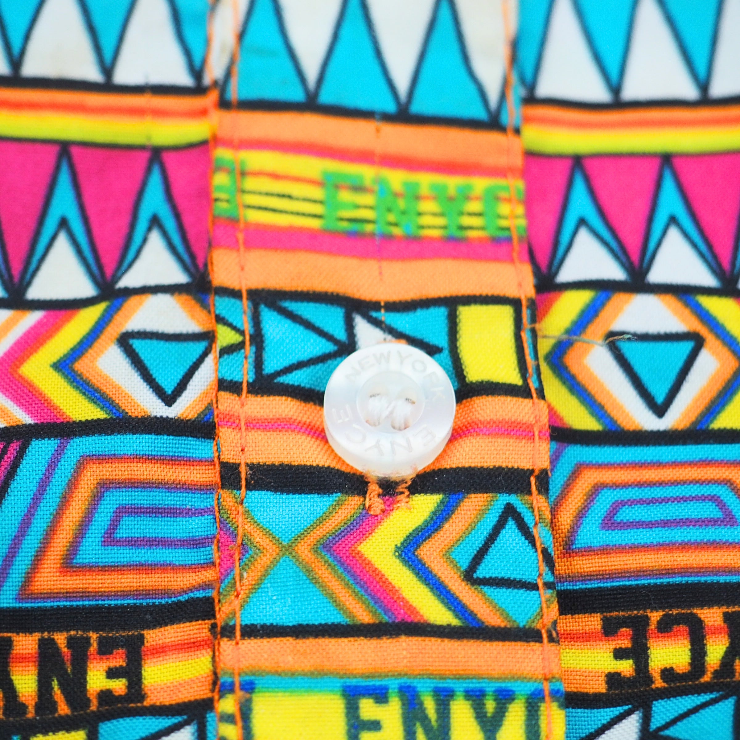 Colorful fabric with geometric patterns and 'ENYCE' branding.