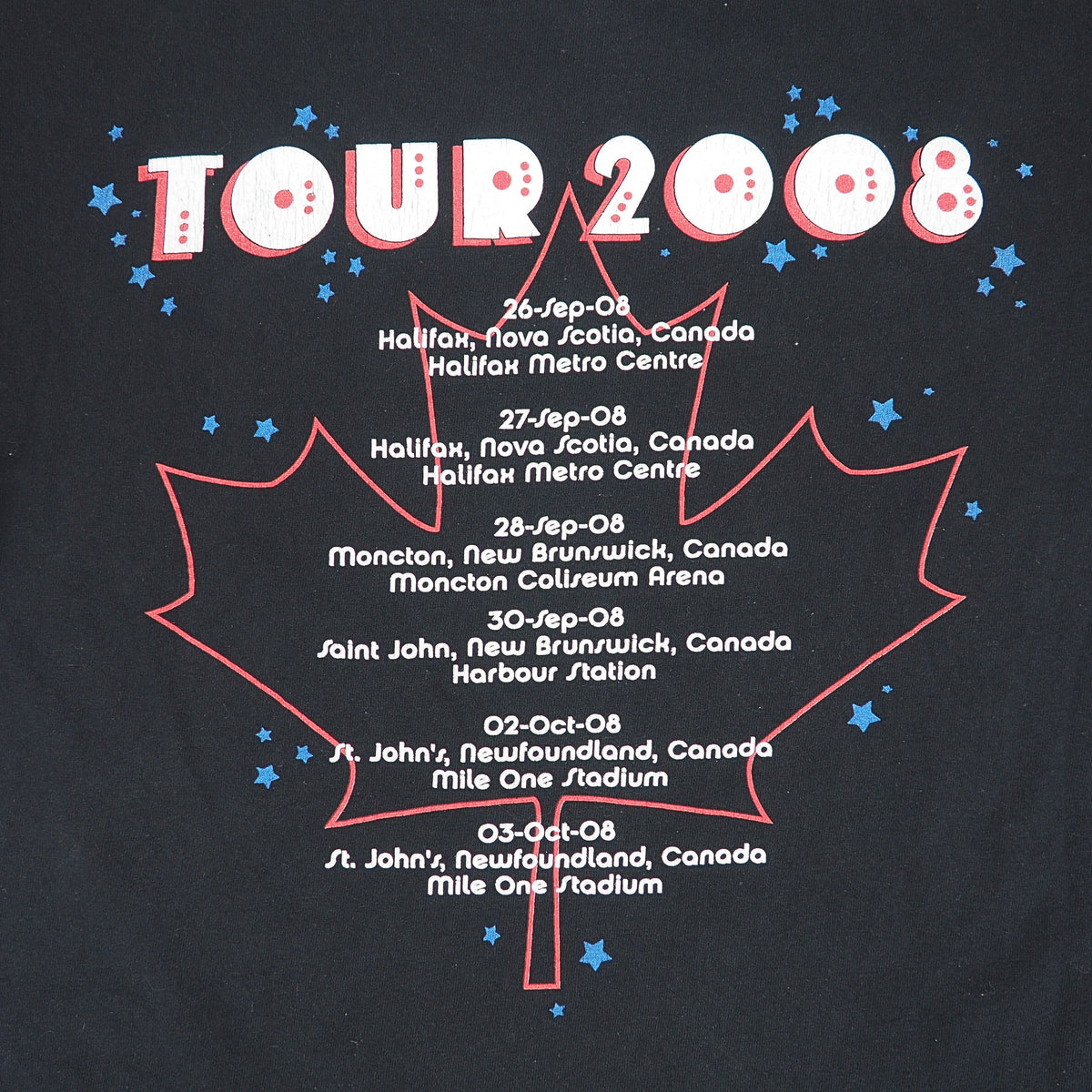 A close-up of a black graphic print featuring a red outlined maple leaf with the text 'TOUR 2008' in large white letters with red outlines, surrounded by small blue stars and a list of tour dates in white text.