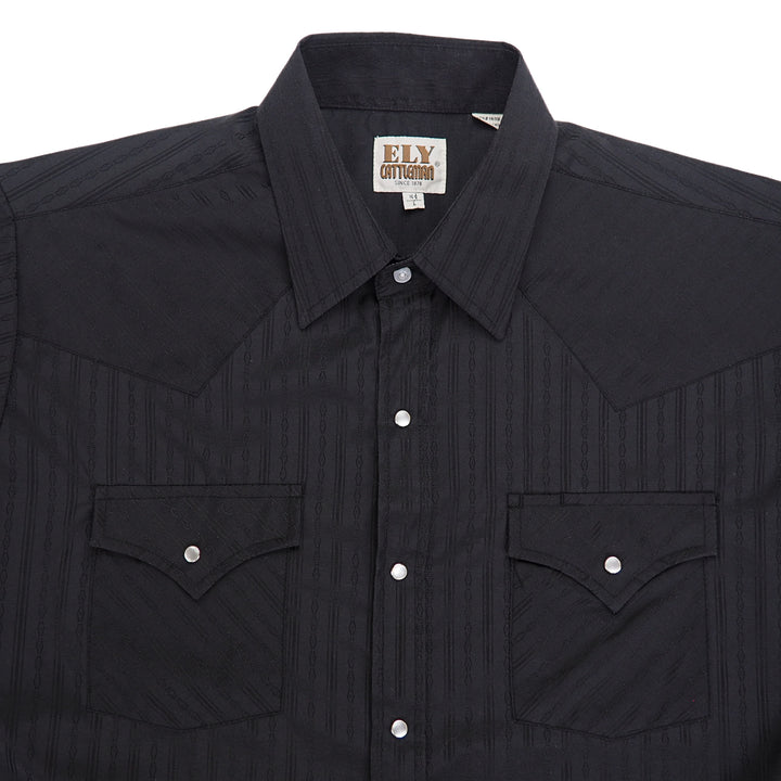 Chest, shoulder and collar area of a black western shirt with pearl snap buttons.