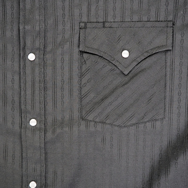 Close up of the front left pocket and placket of a black dress shirt.
