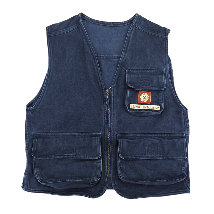 A dark blue denim utility vest with multiple front pockets, a central zipper, and a small 'Esprit Desert' patch on the chest pocket, shown against a plain white background.