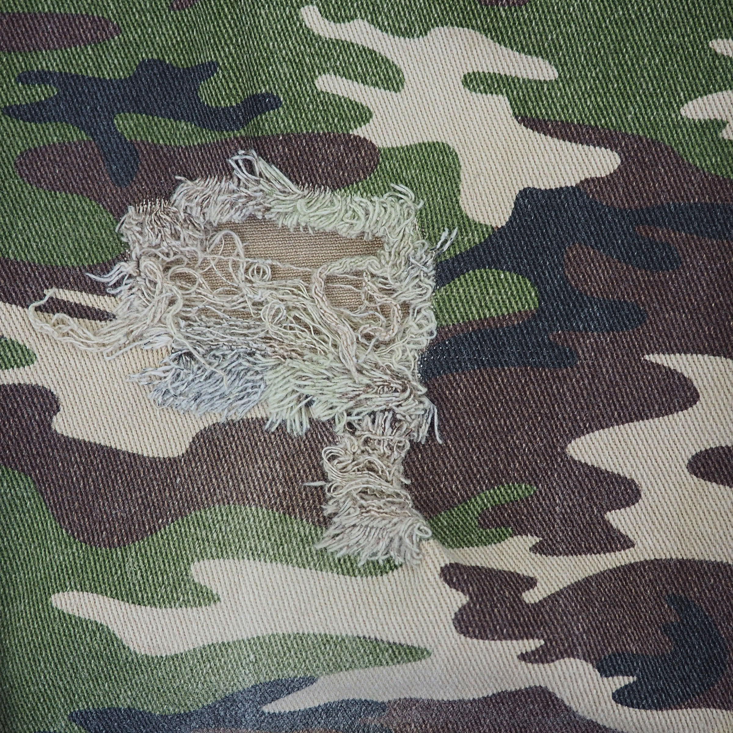 Ripped patch on camouflage fabric