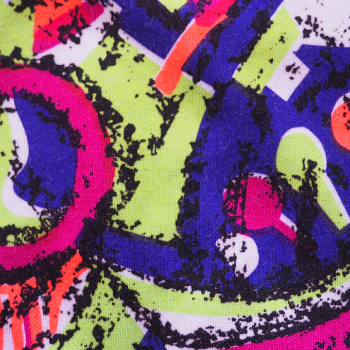 Close-up of colorful abstract pattern fabric with pink, green, and blue colors.