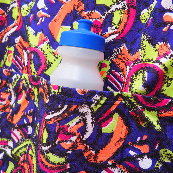 Colorful patterned fabric with a blue and white water bottle tucked inside a pocket