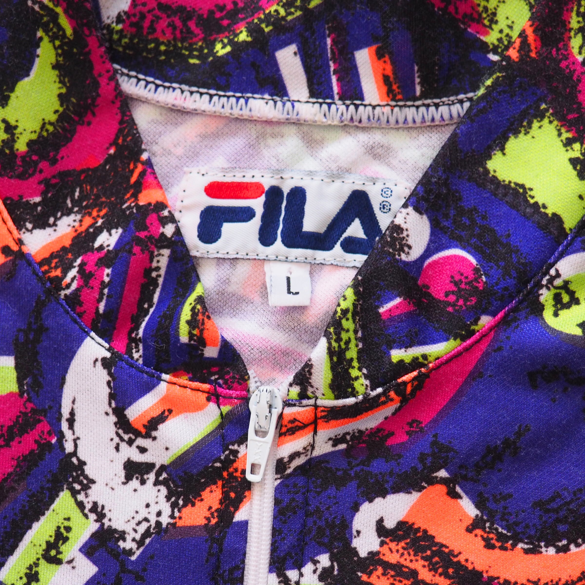 Close-up of the inside collar of a colorful cycling jersey with a FILA logo tag.