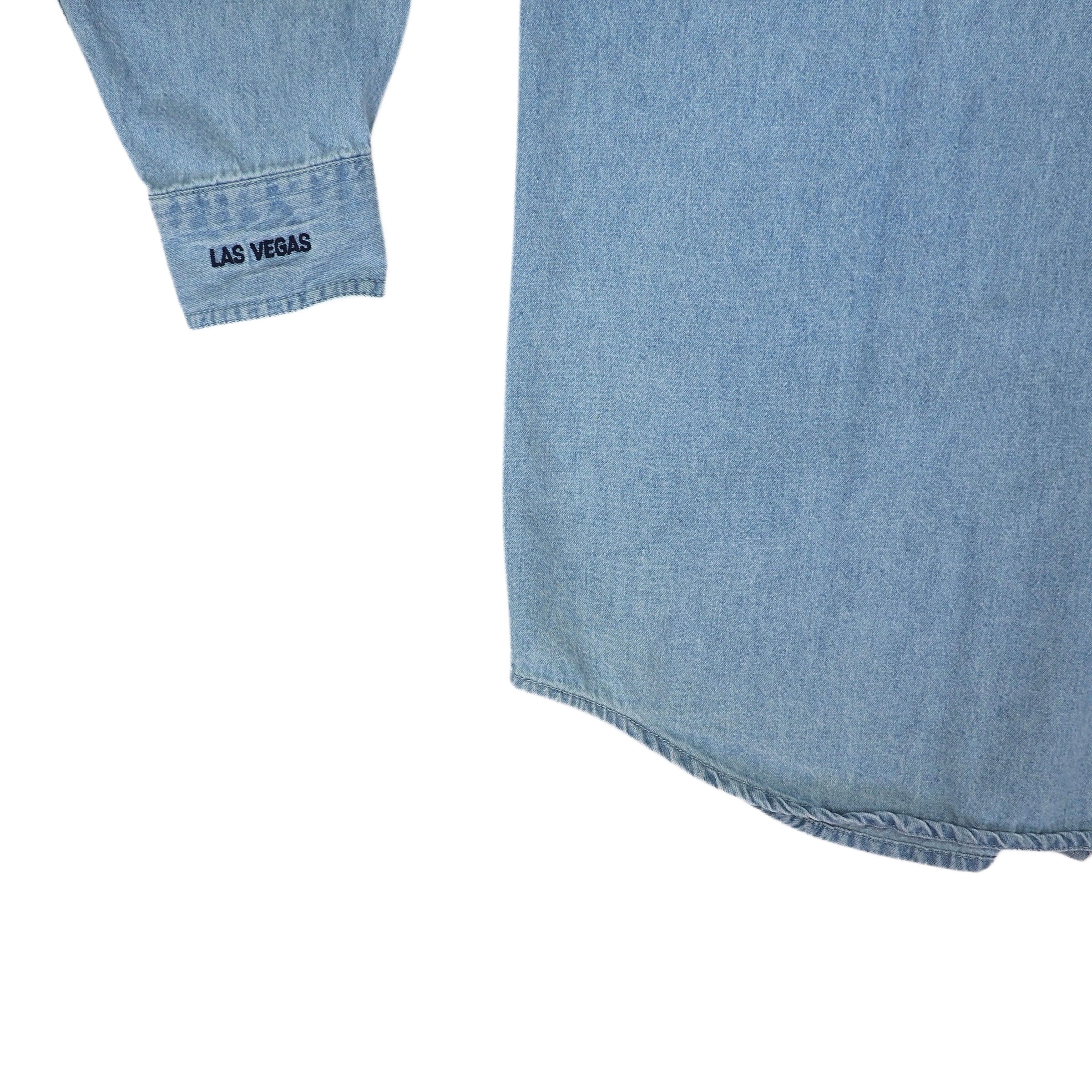 Light blue denim shirt tail and Las Vegas embroidered sleeve cuff on a white background