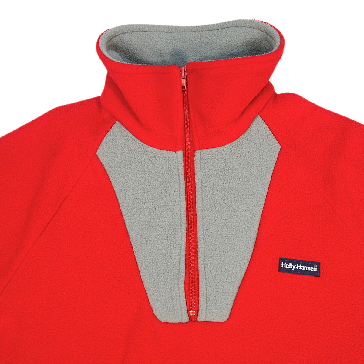 A red fleece quarter-zip pullover jacket with a gray inner lining and gray front placket, featuring a small black and white Helly Hansen logo patch on the left chest.
