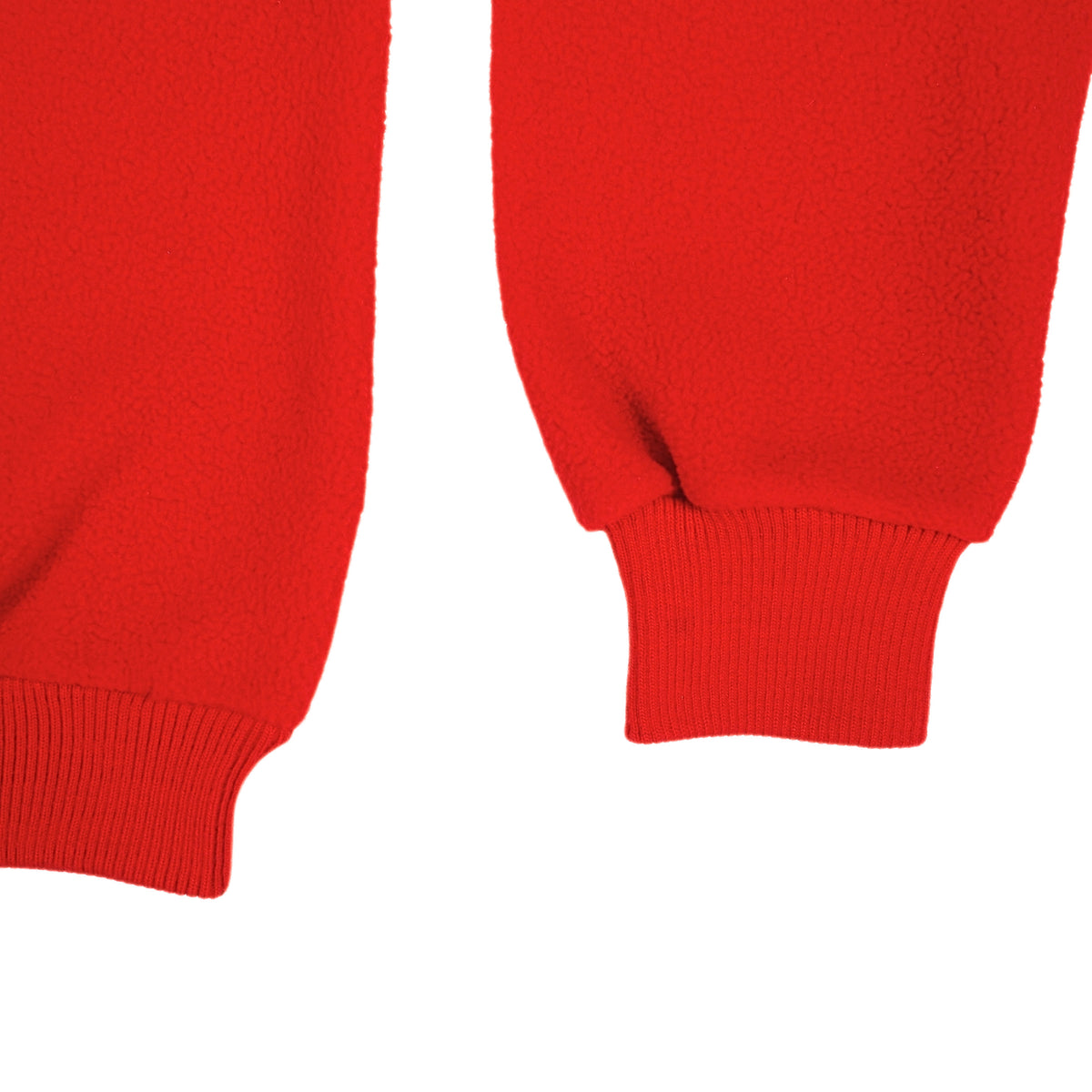 Close-up of bright red fleece fabric showing two ribbed cuffs on a plain white background.