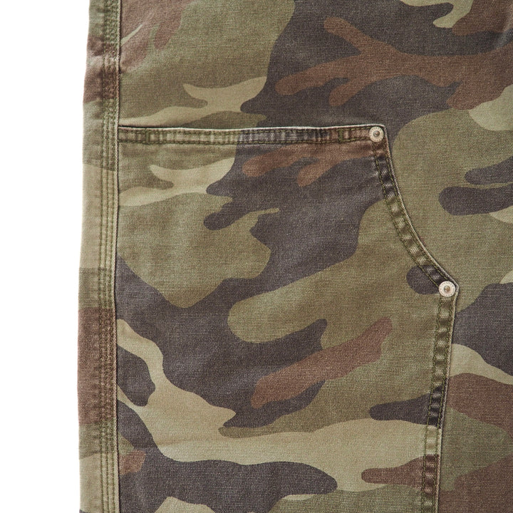 Close up of rivets and seams on the pocket of a pair of camouflage cargo pants.
