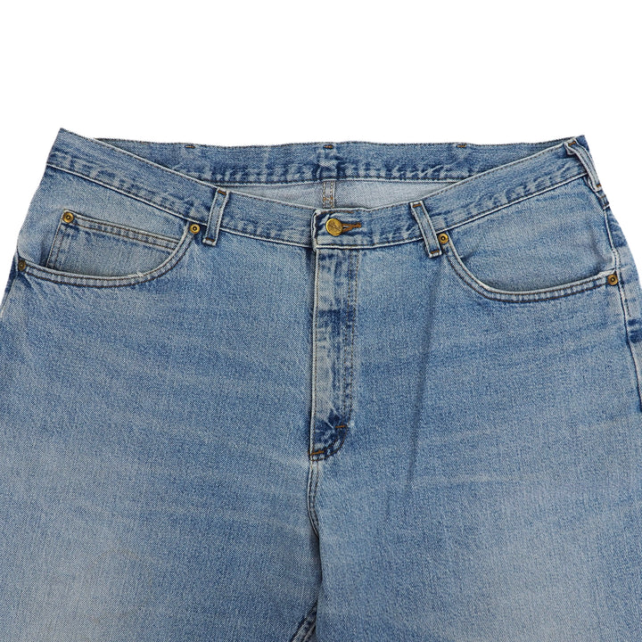 Front pockets and waist area detail of a pair of blue denim jeans on a white background