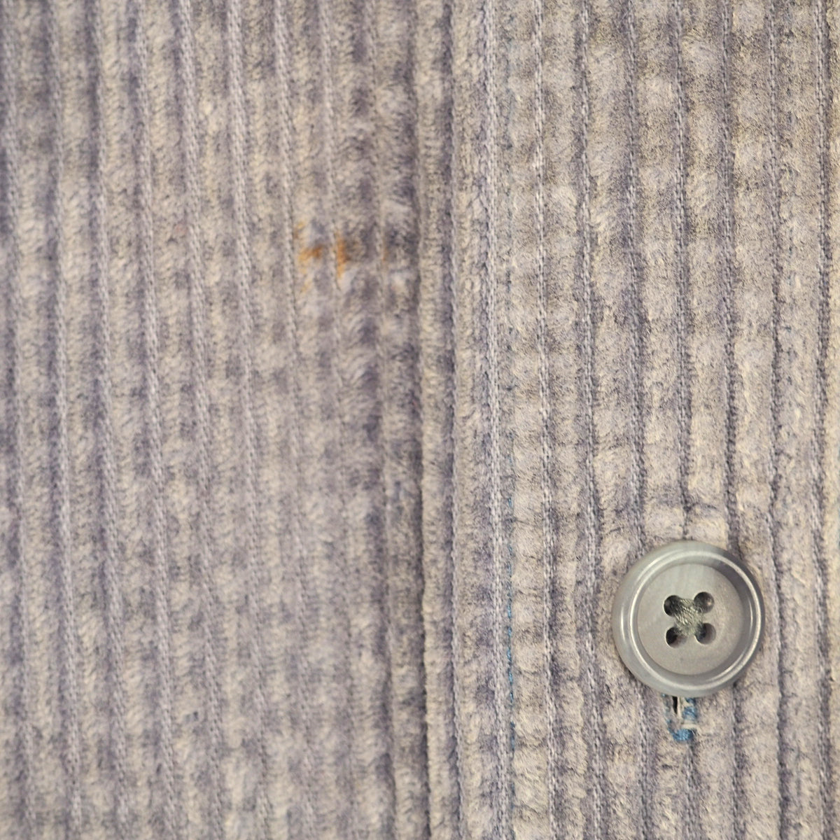 Close-up of a textured gray and white striped knit fabric with a silver four-button snap closure.
