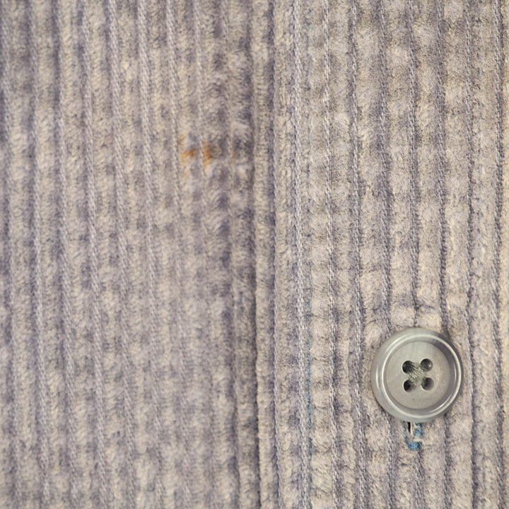 Close-up of a textured gray and white striped knit fabric with a silver four-button snap closure.