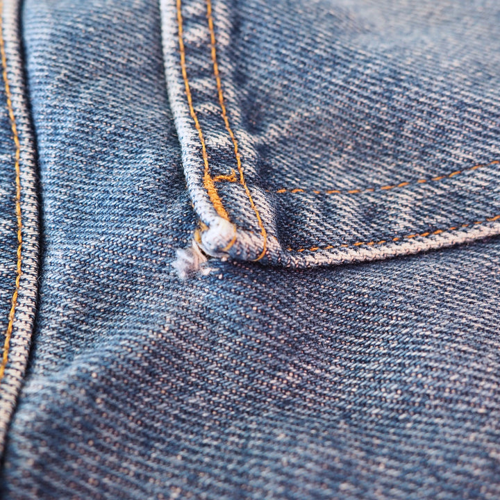 Close-up of blue denim fabric with stitching details
